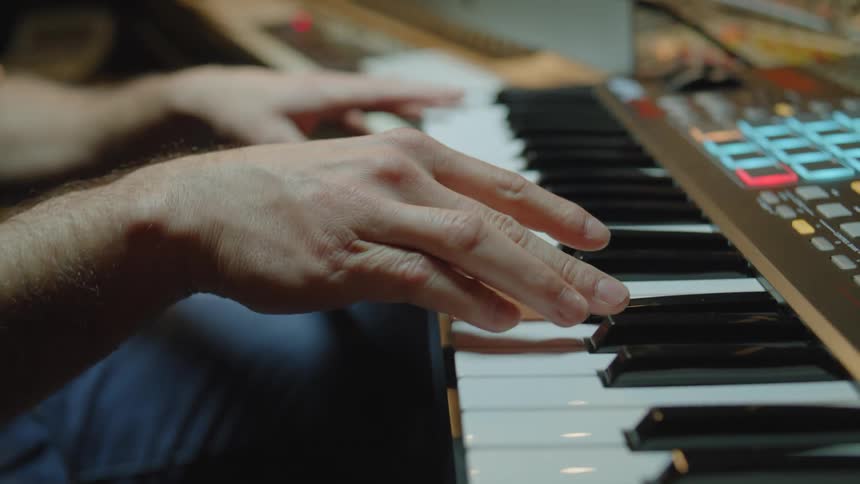 A pair of hands playing on a keyboard