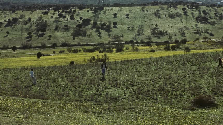 Three people running to a meeting point on a plane grass land