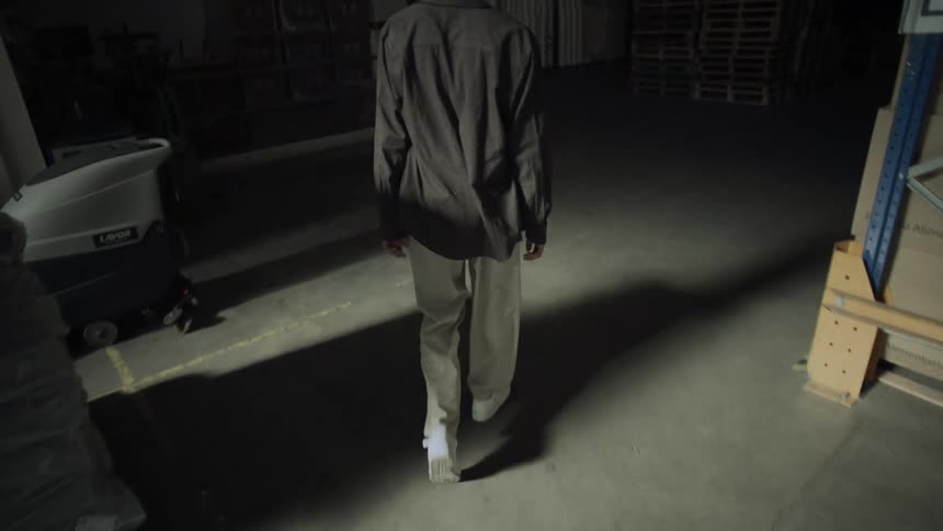 Man walking inside a warehouse with boxes and pallets