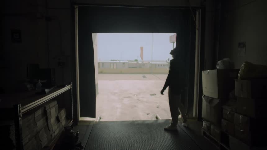 Man opening the door of a warehouse from the inside
