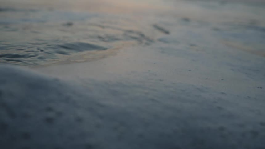 Ocean waves disturb foam floating on surface of water