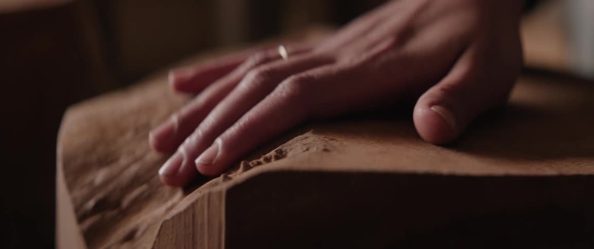 A person traces their hand on the wood