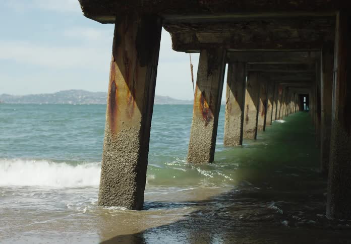 A clip of a sea shore under bridge