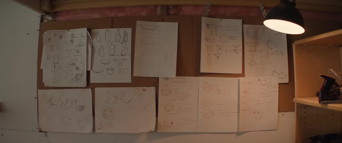 Designs for sculptures hanging on a corkboard