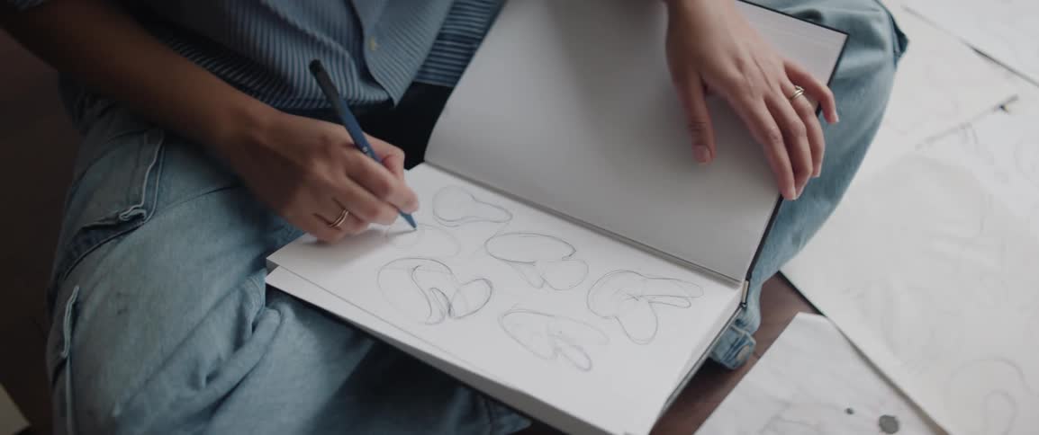 A lady sketching designs in her book