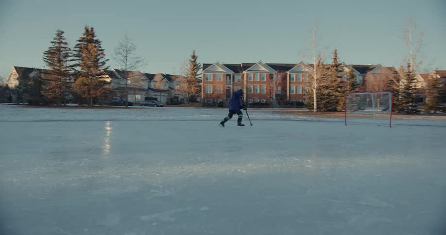 A man plays ice hockey on the frozen lake