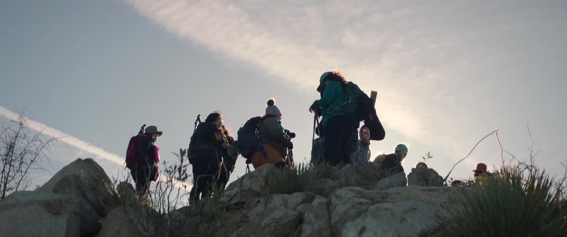 A group of hikers pause on top of a rocky hill
