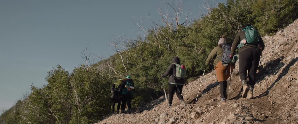Group of women hiking in the mountains on a cloudless bluesky day