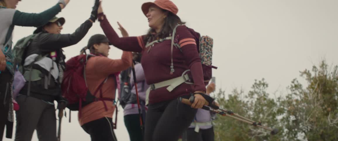 A clip of hikers shaking smiling and giving a warm welcome to a fellow hiker