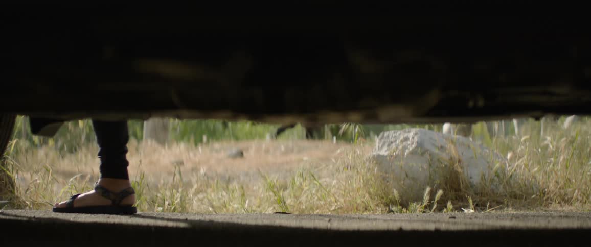 Feet walking by as seen from under vehicle