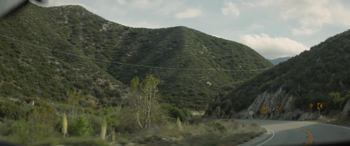 Vehicle drives down winding road in mountainous area