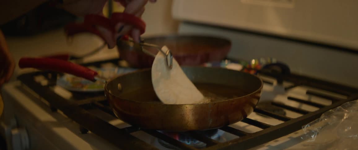 A woman frying tortillas in a pan