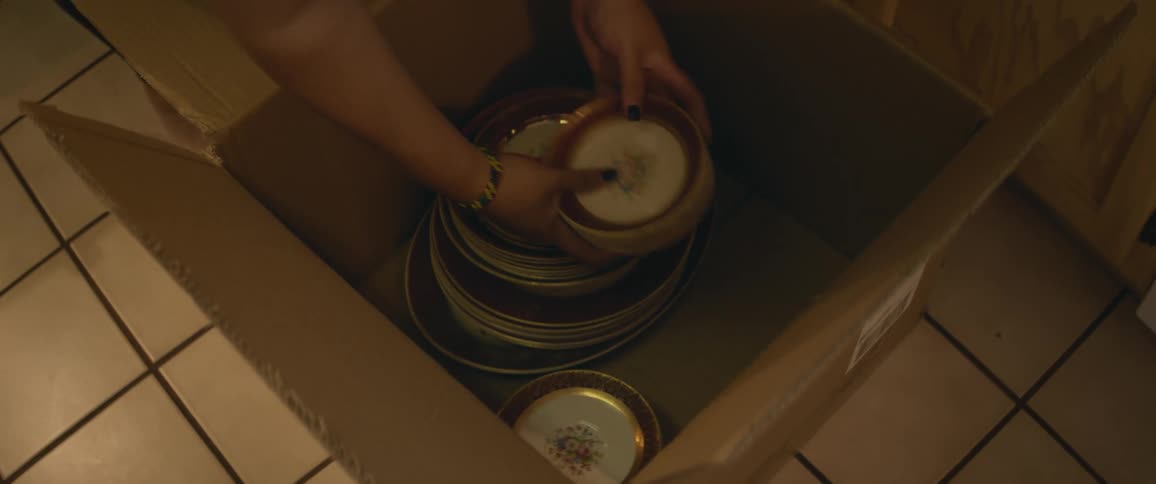 A person arranging plates into a box