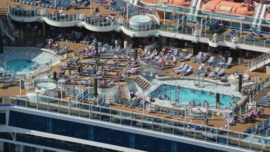 Crowd of people inside or around a pool on top of a cruise boat during day time