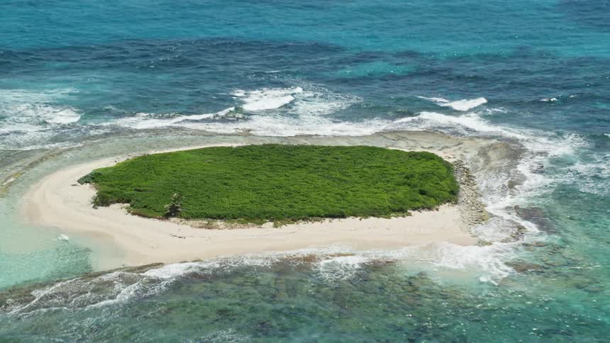 Aerial view over an islet on a clear sea