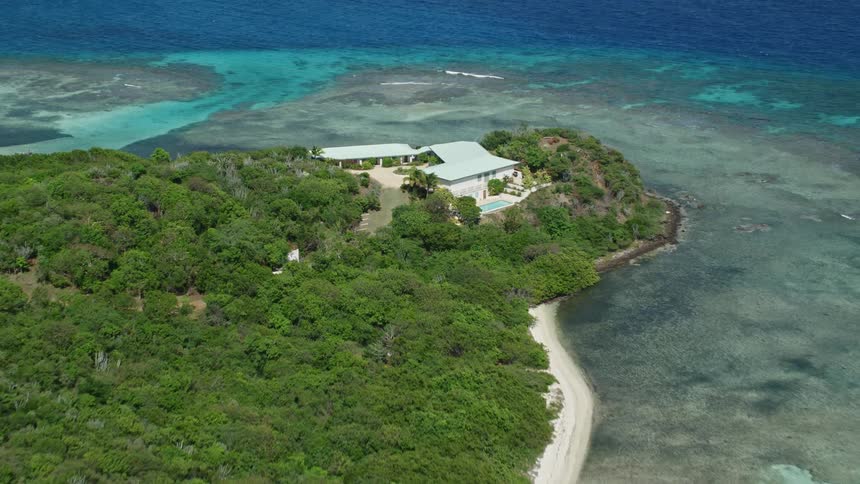 A mansion is on the tip of the tropical island