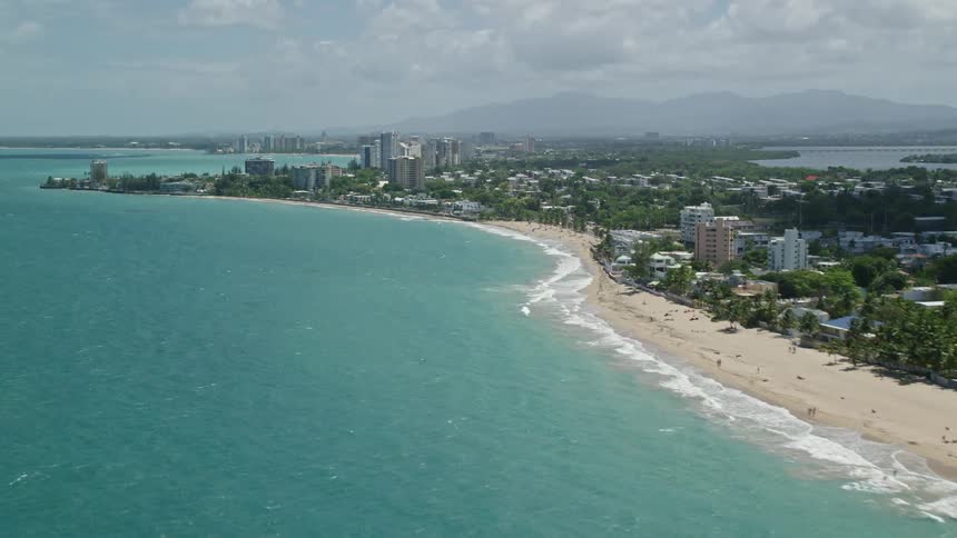 A large city that faces the sea and there is a large beach between the city and the sea