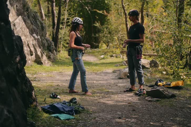 Woman teaching rock climbing techniques to a teenager