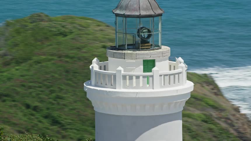 Aerial view of a lighthouse tower on a hill by the sea