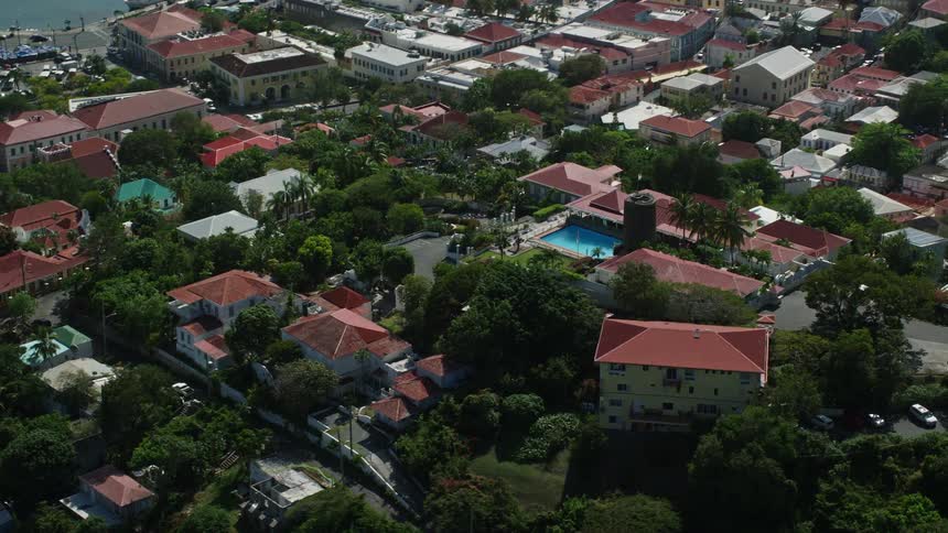 Aerial panorama of an urban city nestled among hills facing the sea