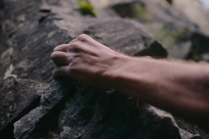 A persons hand holding a stone
