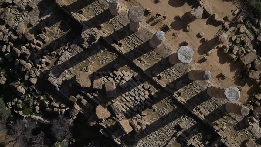 A broken down building with pillars lies below