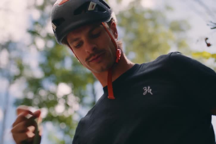 A man wearing a safety helmet is stretching a rope with his hands