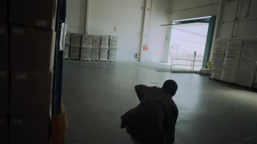 A man dances across a warehouse