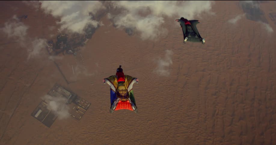Two jumpers soar through the air to the earth