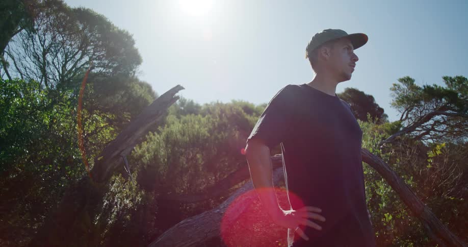 A man standing in the forest contemplating the landscape