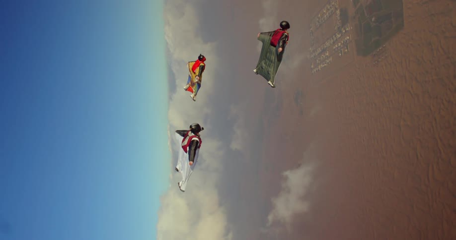 Three men soaring in wingsuits