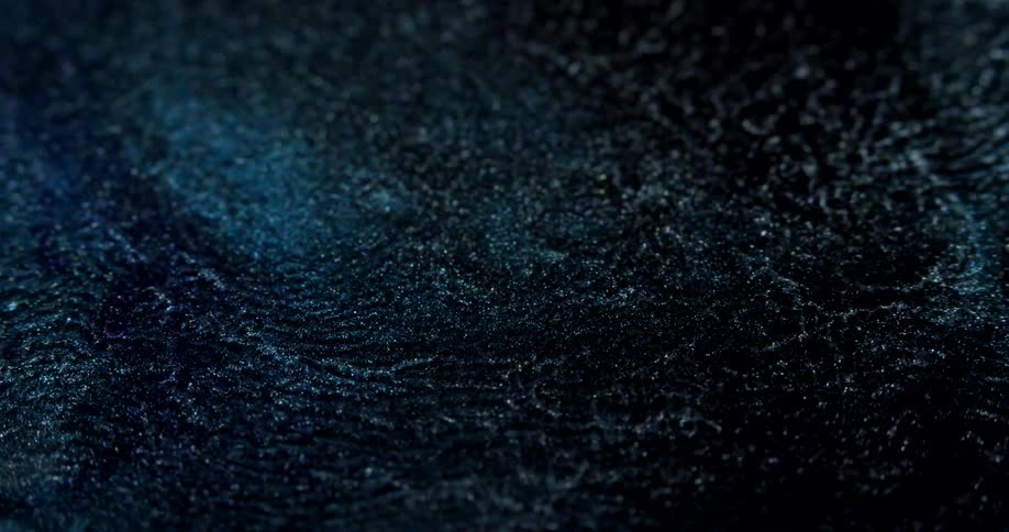 A blue reflection on the surface of a body of water at night