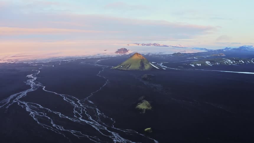 Aerial panorama of a volcano with black terrain around under a morning sky in winter