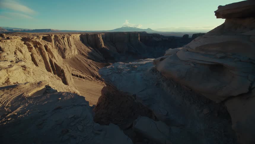 A rocky desert valley partly in shadow
