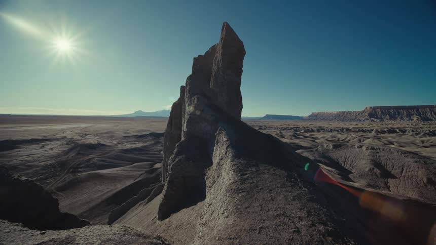 A jagged rock formation towers above this arid landscape below