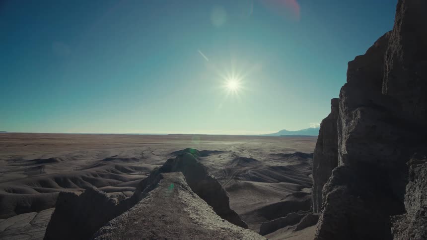 Aerial of a desert with brown mountains on a sunny day