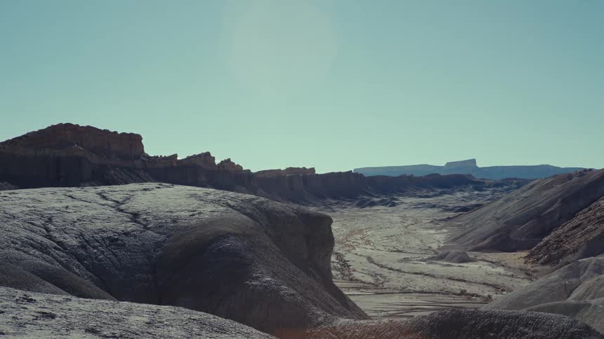 A landscape scene of a valley in the desert with mountains in the distance