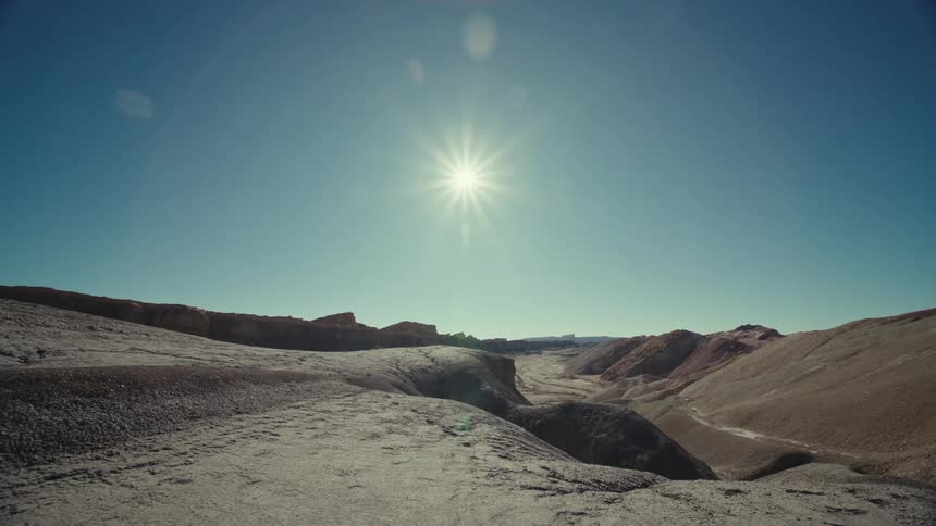 Sun shines onto arid valley and surrounding mountains