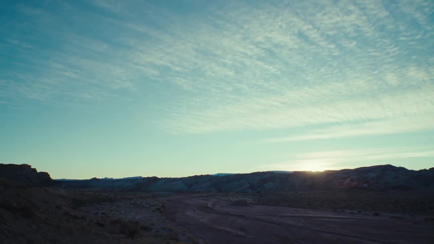 A rocky desert landscape partly in shadow