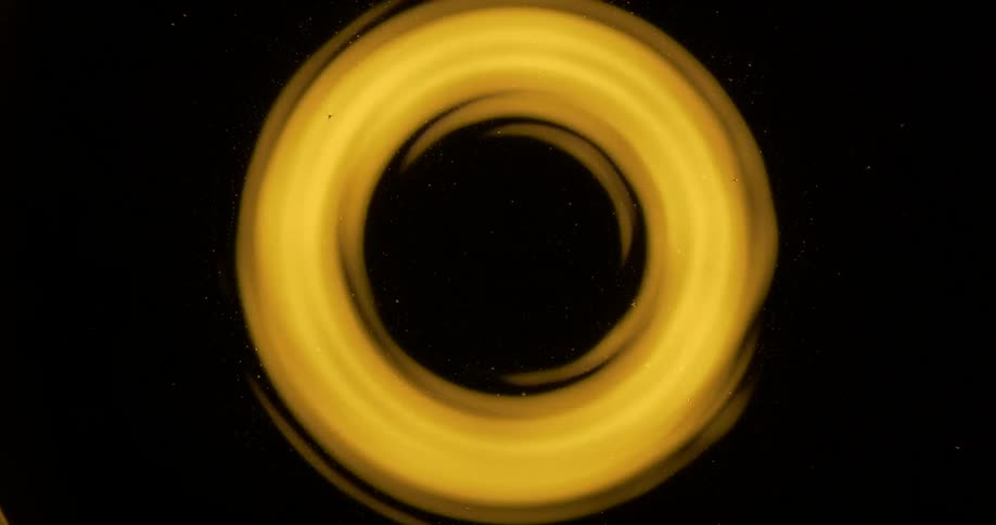 Extreme closeup of an abstract yellow light on a black background in a circular shape