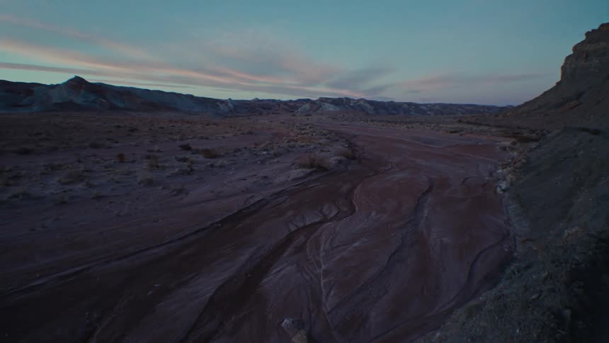 Panorama of a muddy terrain with geological canyons around it in the morning