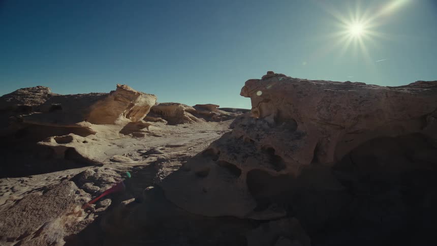 A rocky desert landscape partly in shadow