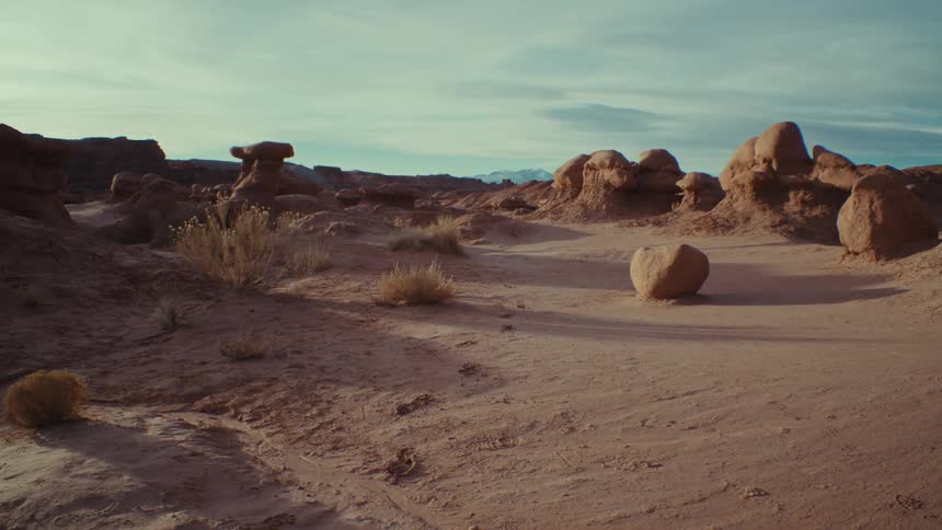 Geological rocks amidst a desert terrain with canyons in the background