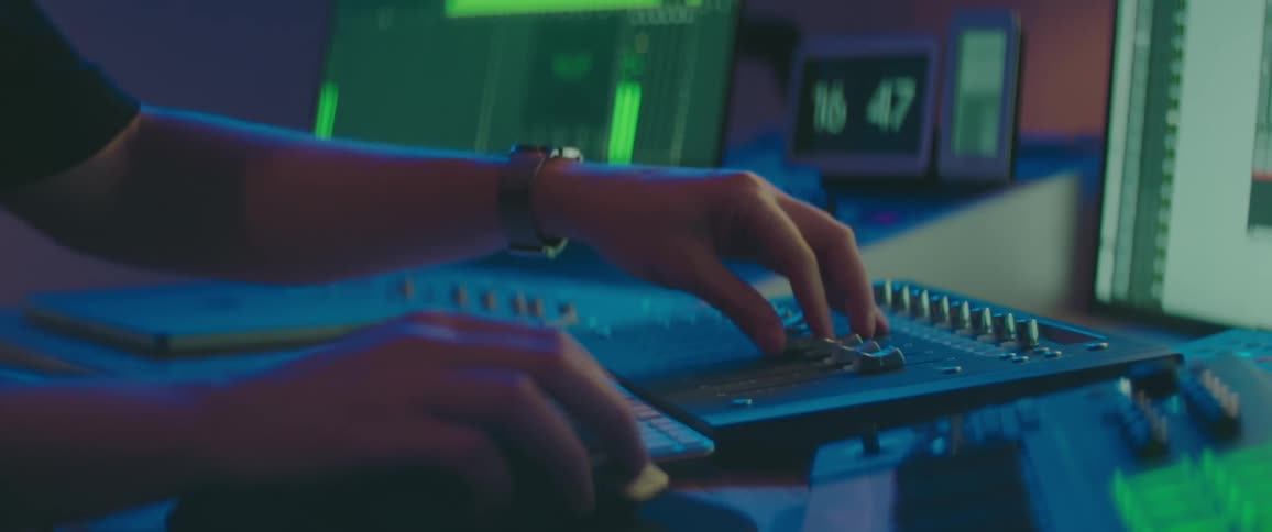 A person using a mixing board in a recording studio