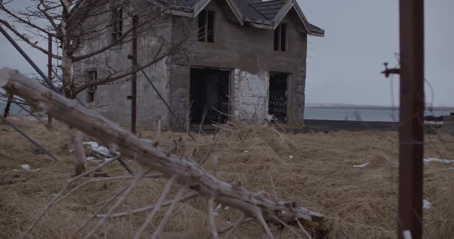 A run down house with a dead lawn on a cloudy day