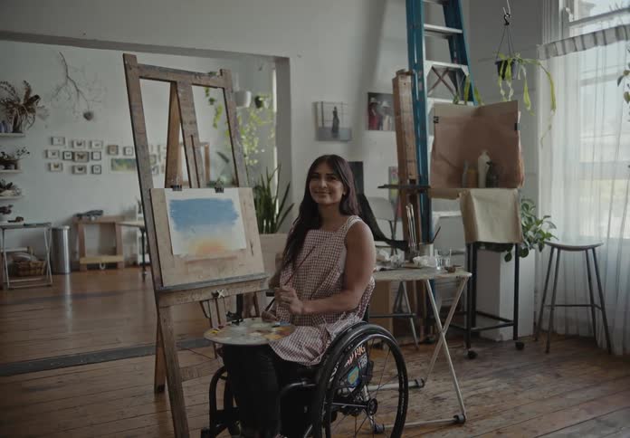 An artist in a wheelchair painting a picture
