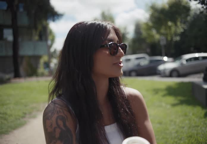 Wheelchair user woman outdoors holding a cup and smiling while talking