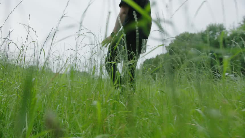 A man is walking through the grass
