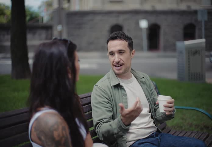 Two friends talk on the park bench