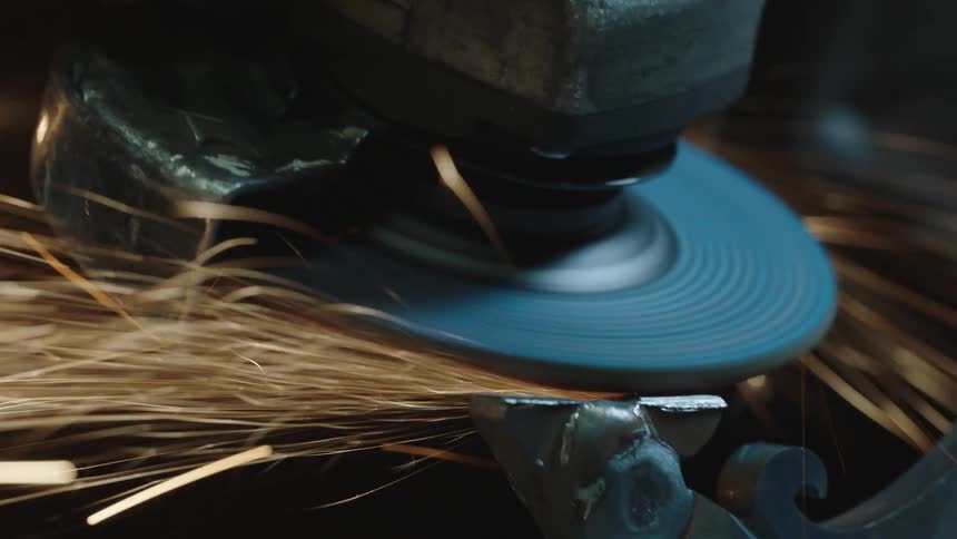 Closeup of a disc machine being applied to metal producing sparks